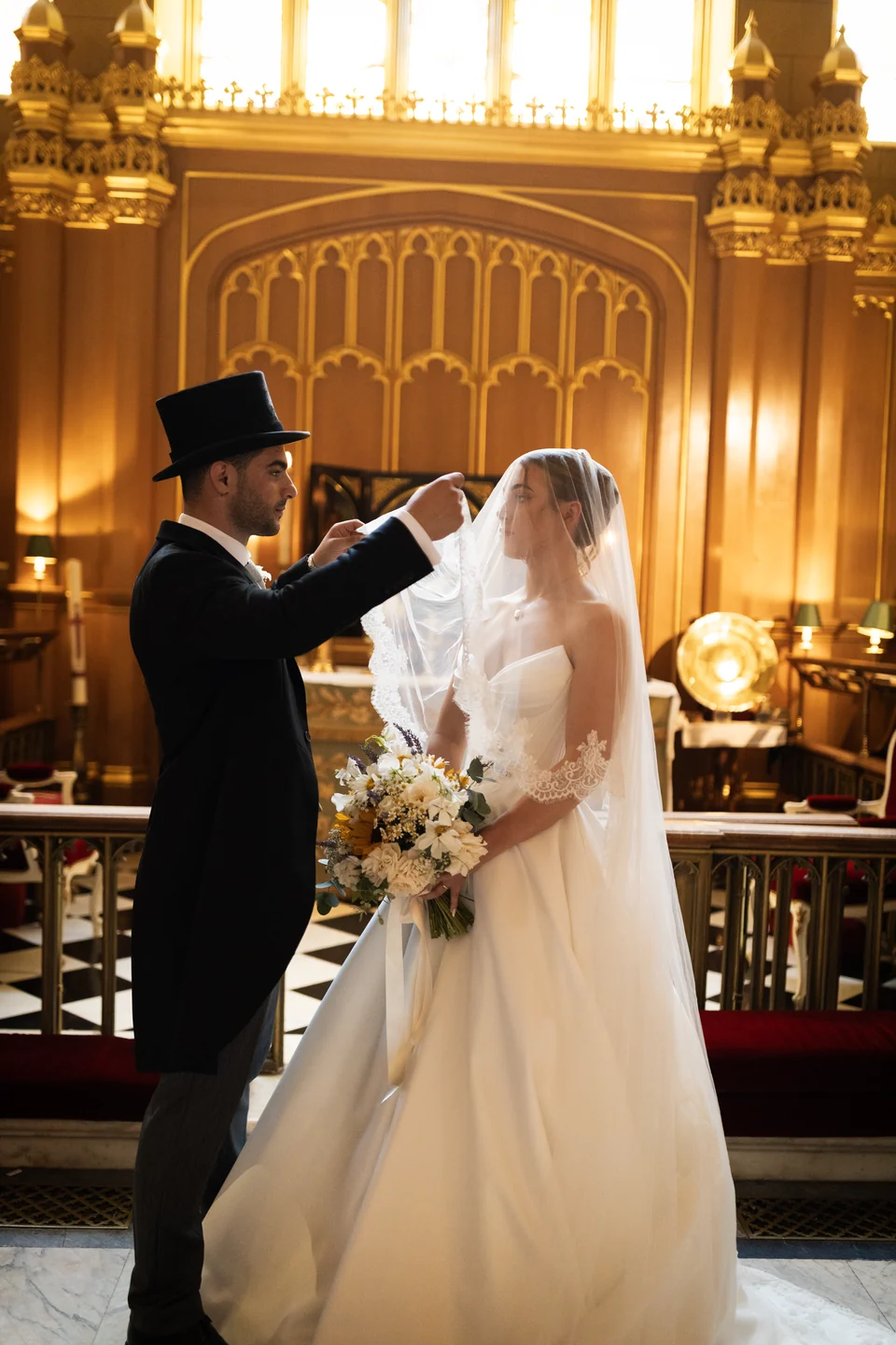 Newlyweds together in an ornate wood-panelled hall