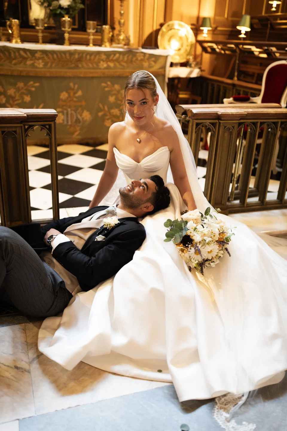Bride and groom sharing a playful moment on a tiled floor