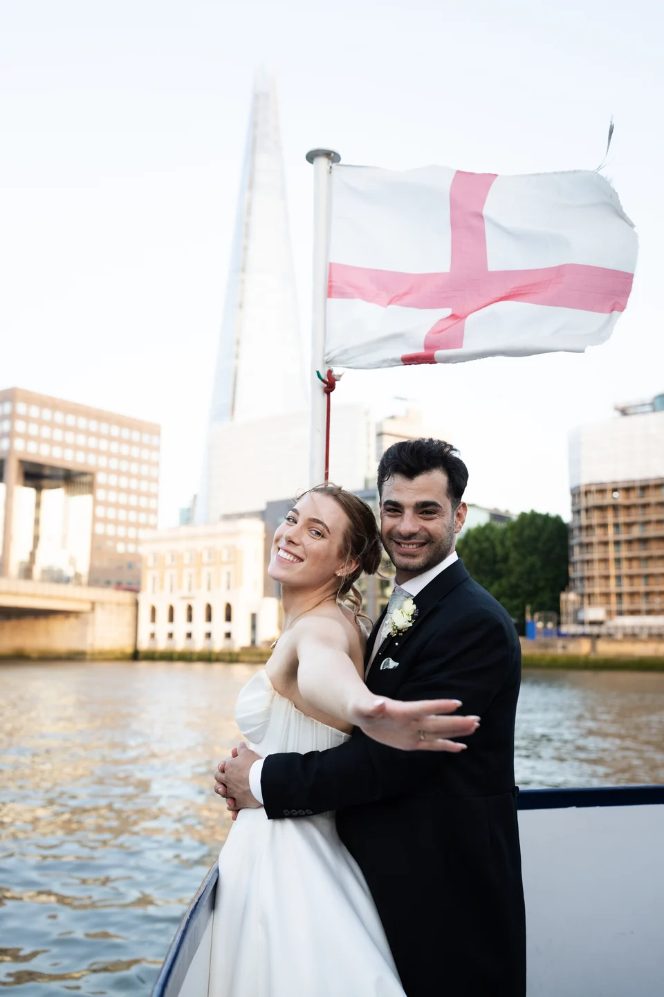 Newlyweds embracing beside the River Thames