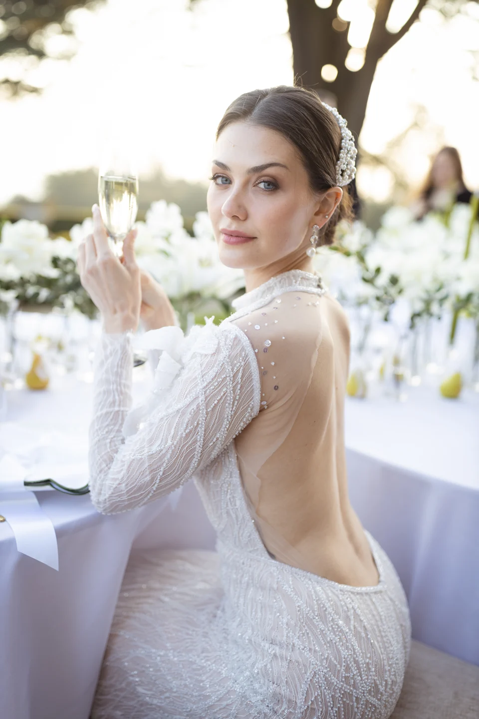 Bride holding flowers beside an outdoor wedding table