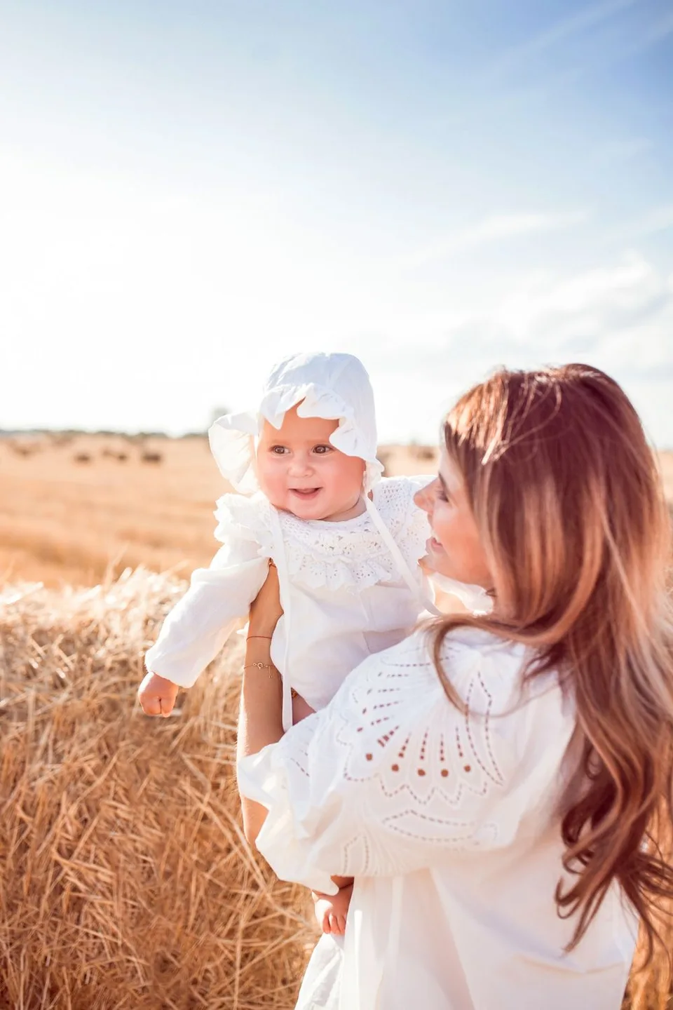 A tender moment captured in a sunlit wheat field on a bright summer day.