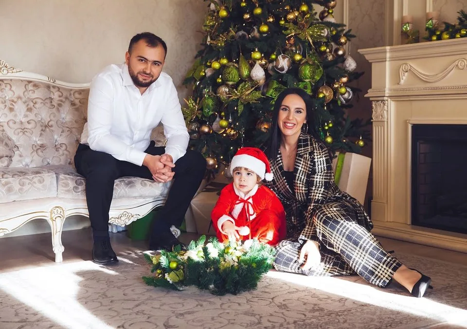 Cozy Christmas family scene with decorated tree and holiday decorations.