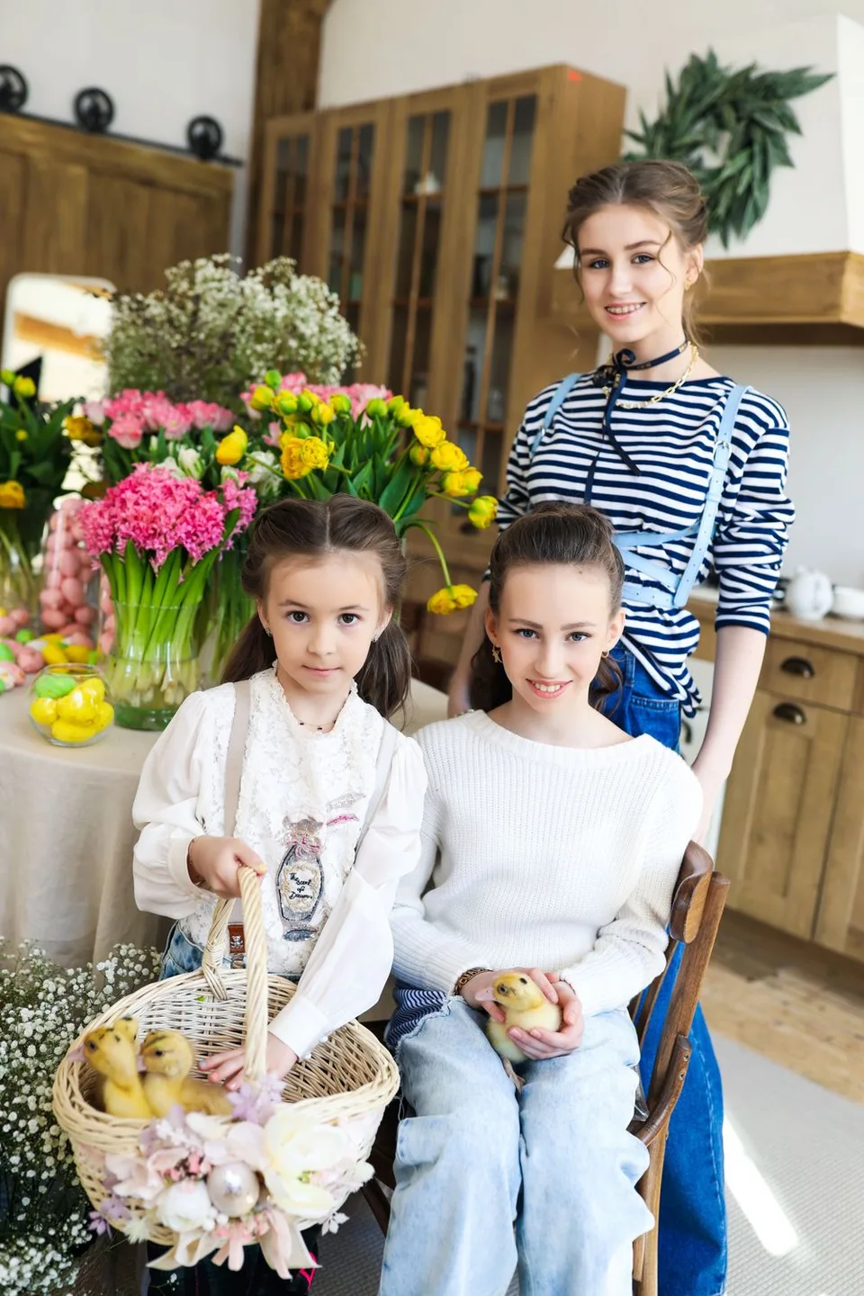 A spring scene in a kitchen with colorful flowers, a decorative basket and wooden furniture.