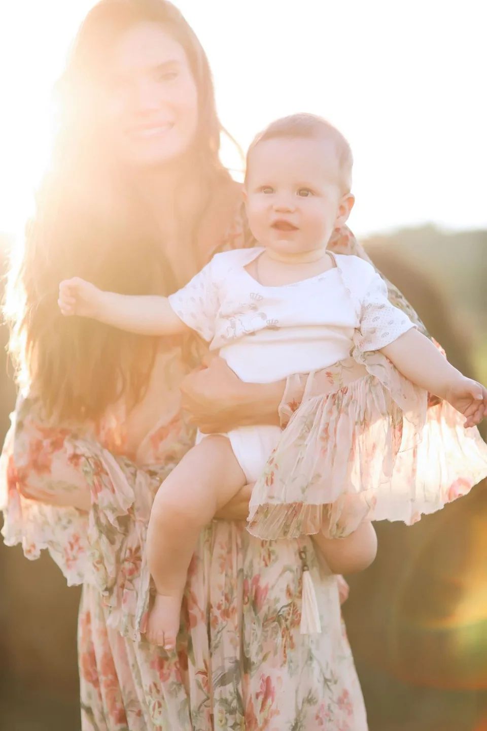 Backlit portrait in floral dress during golden hour sunset.