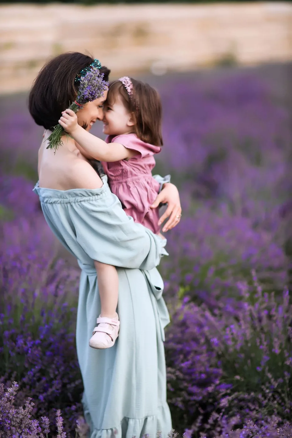 Sweet moment captured in blooming lavender field with flowing blue dress.