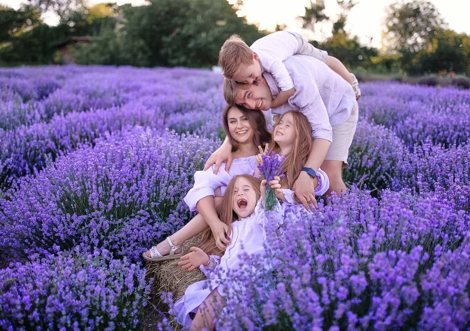 A joyful family moment captured in a vibrant purple lavender field at sunset.