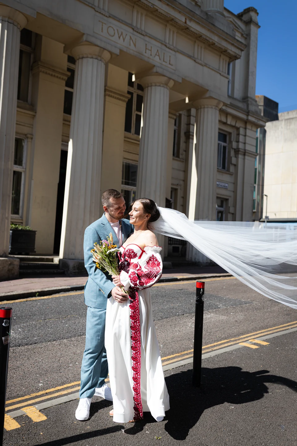 Lena and Arturs outside Brighton Town Hall, with Lena’s veil blowing in the breeze