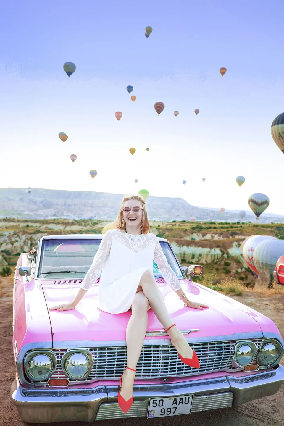 Pink car and hot-air balloons in Cappadocia