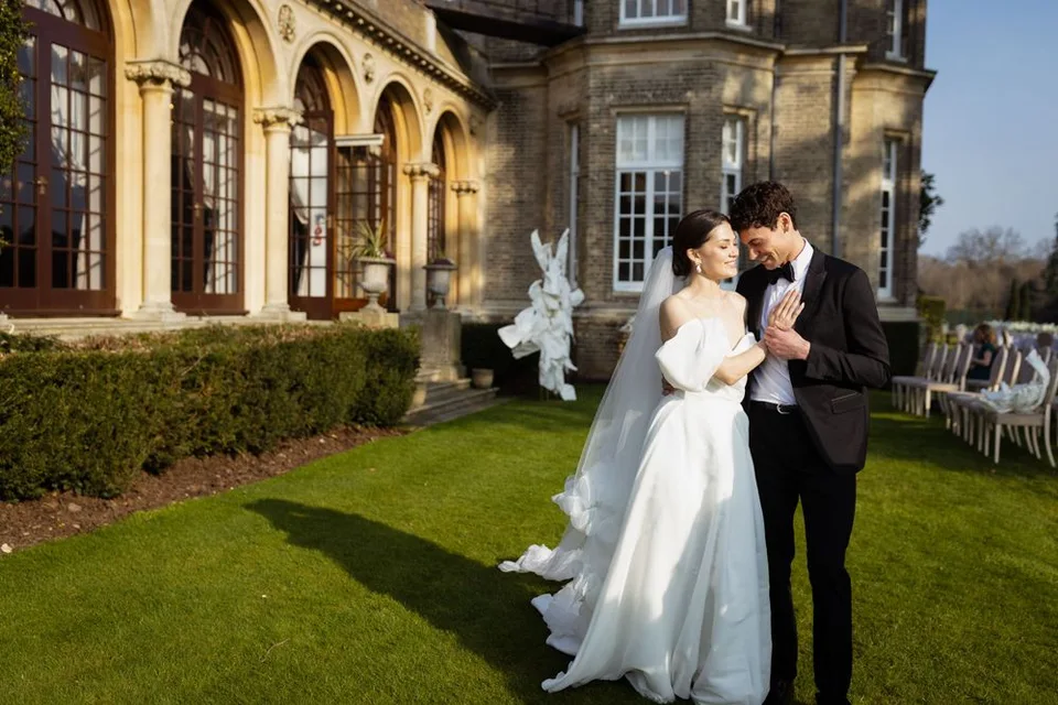 Candid moment of the couple laughing together during their wedding reception in Sussex, capturing their happiness.