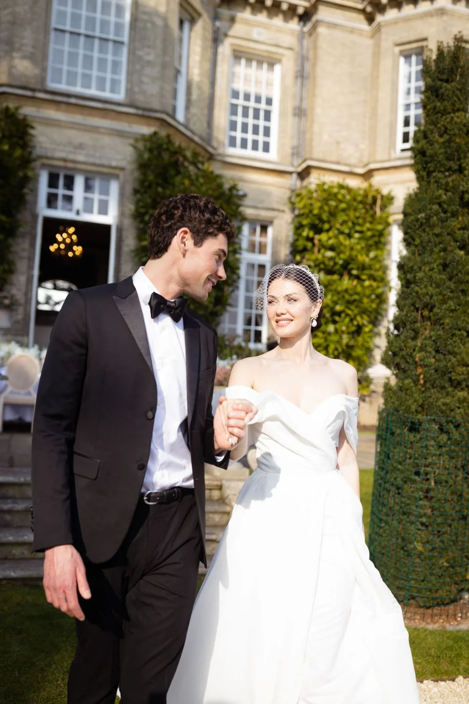 Couple walking hand in hand through a scenic landscape in East Sussex, capturing the romance of their wedding day.