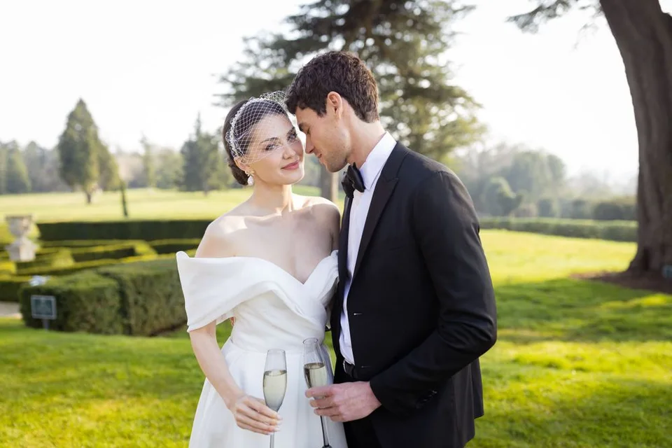 Couple walking hand in hand through a scenic landscape in East Sussex, capturing the romance of their wedding day.