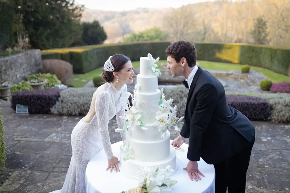 Beautifully decorated cake table at the wedding reception in Kent, showcasing the couple's unique style and theme.