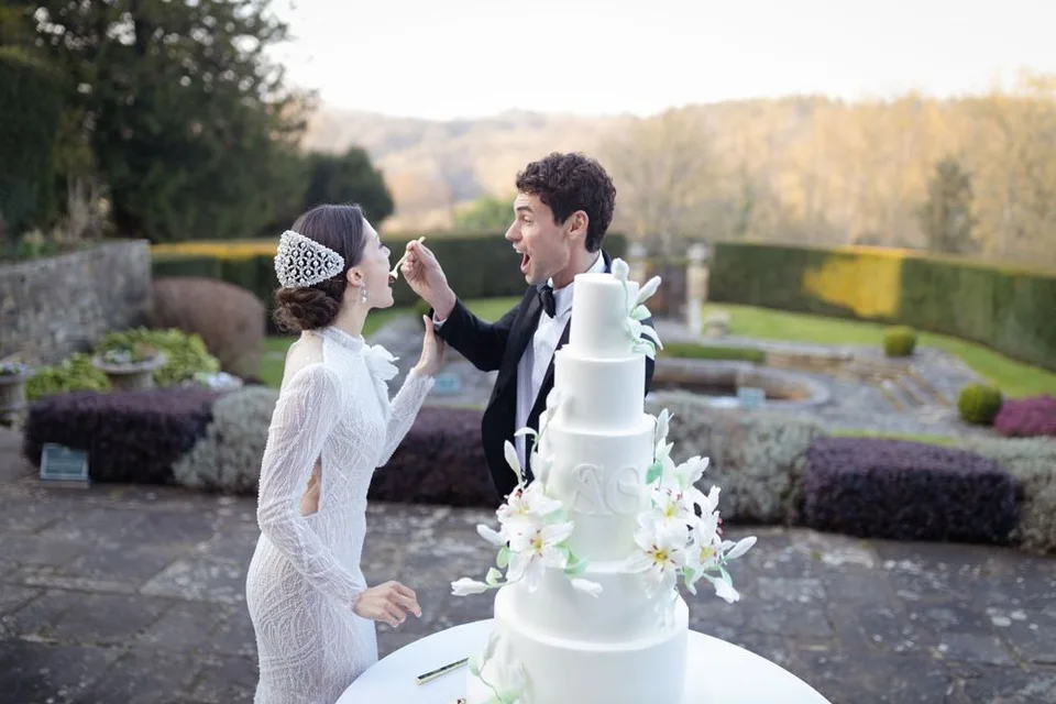 Beautiful bride and groom sharing a romantic moment during their wedding ceremony in Sussex, capturing love and joy eating wedding cake