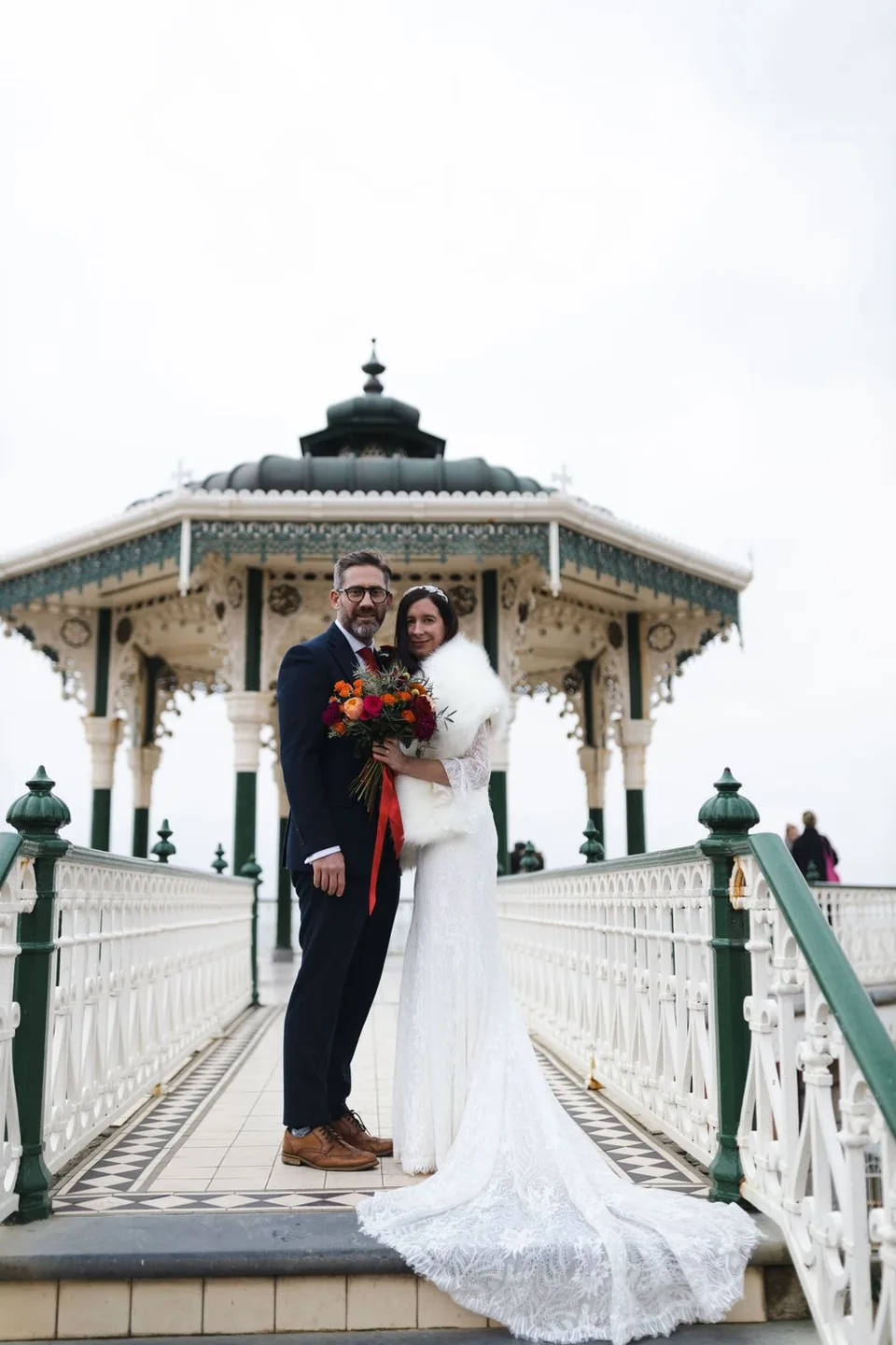 Romantic wedding portrait on an ornate Victorian bandstand with decorative details.