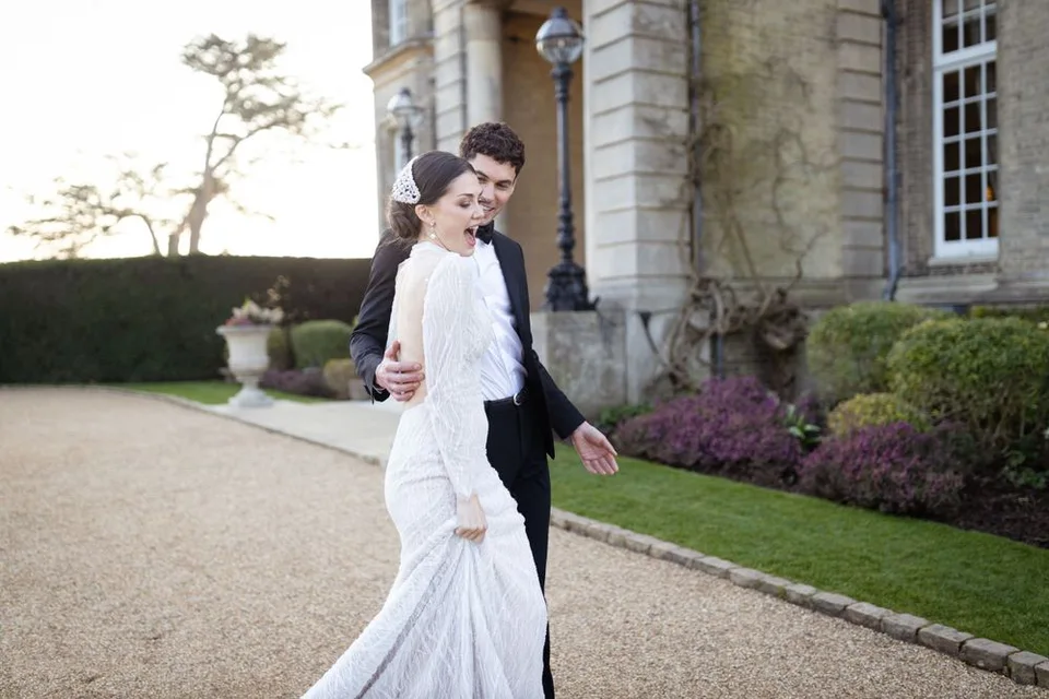 Couple enjoying a fun moment during their wedding photoshoot in Sussex, showcasing their playful side.