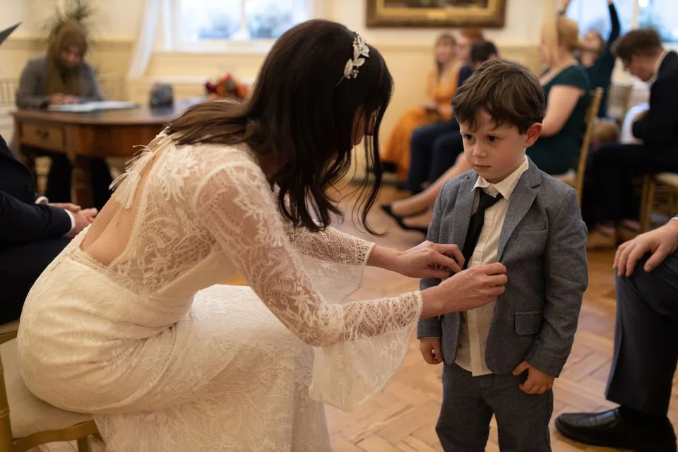 A sweet interaction between young ring bearer and bride in an elegant indoor setting.