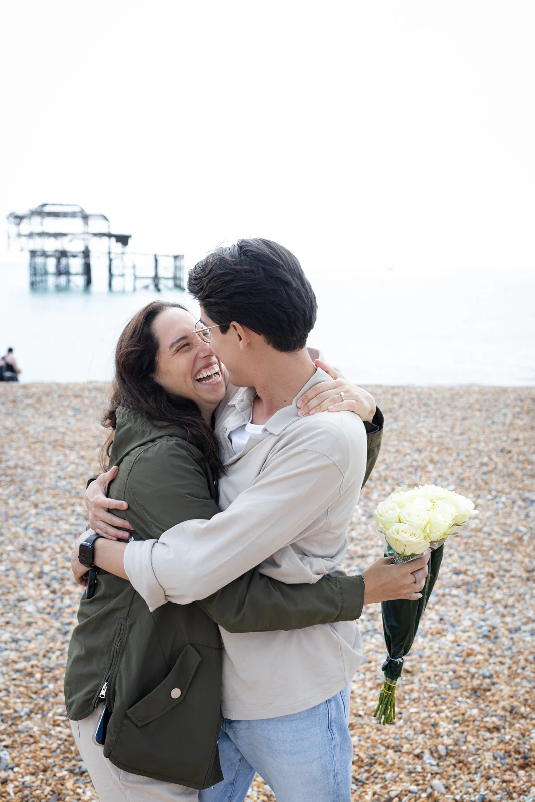 A couple embracing on Brighton beach.