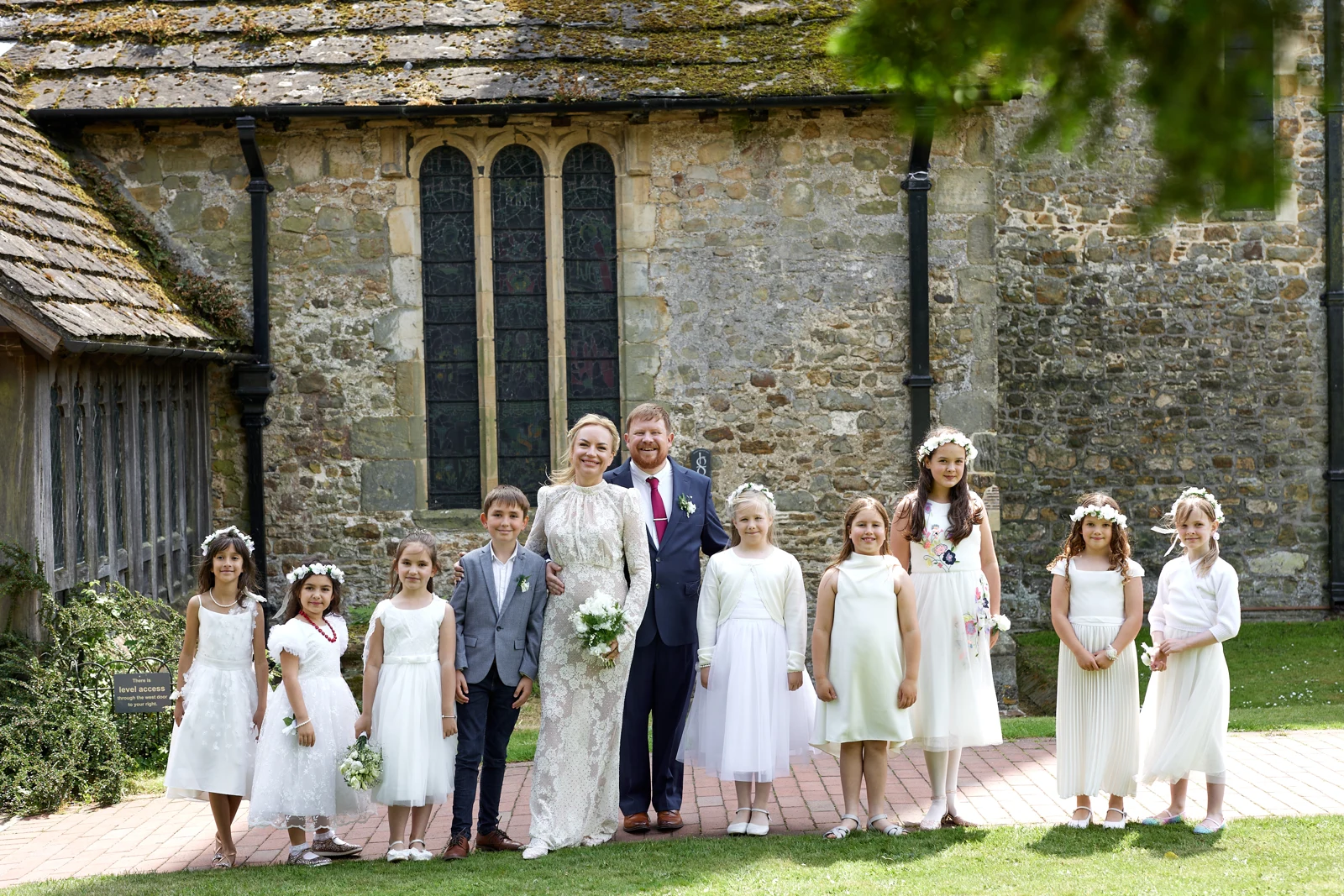 Kate and Rob with the children outside the stone walls of Cuckfield church.