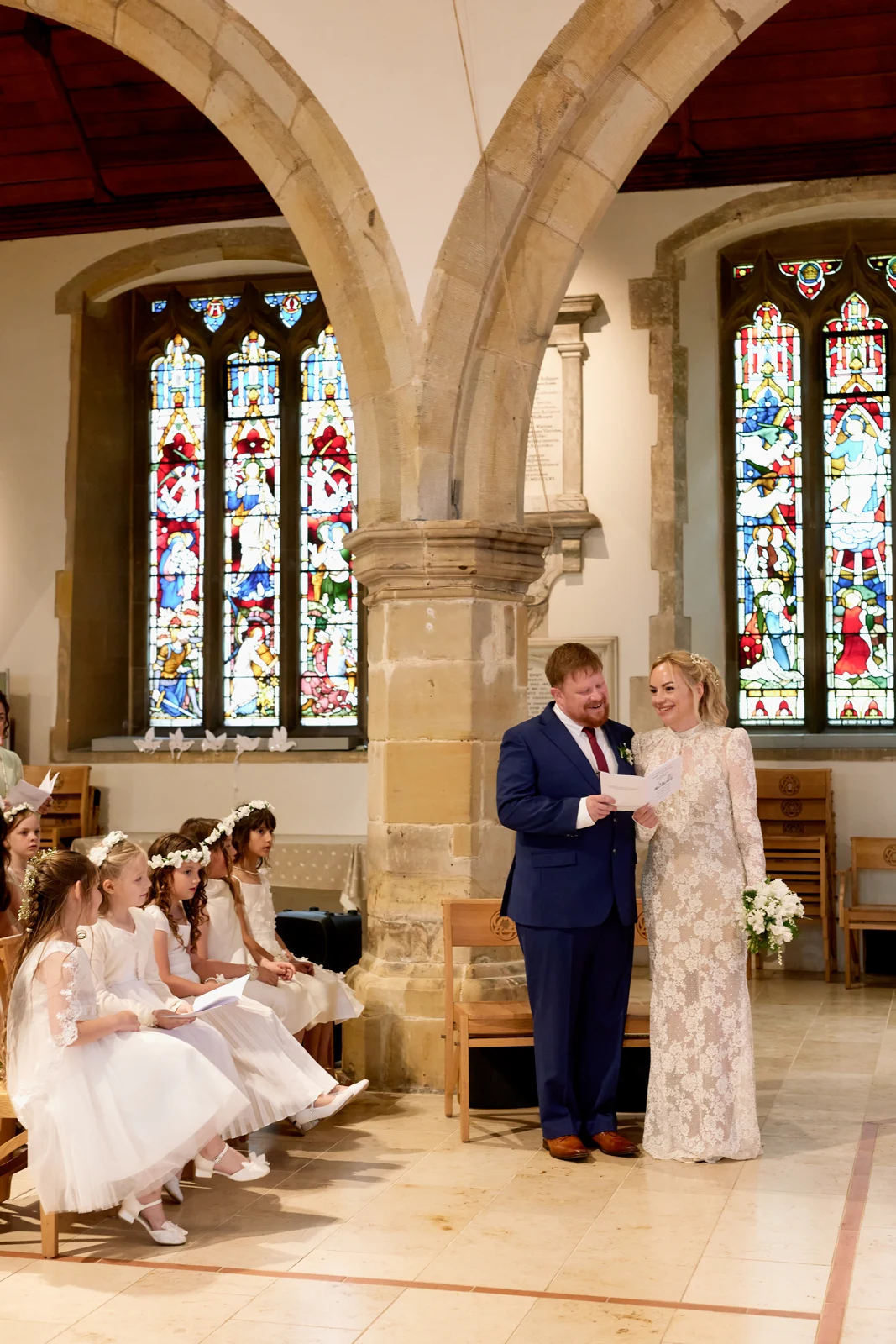 Kate and Rob smiling during their church service, with children seated beside them.