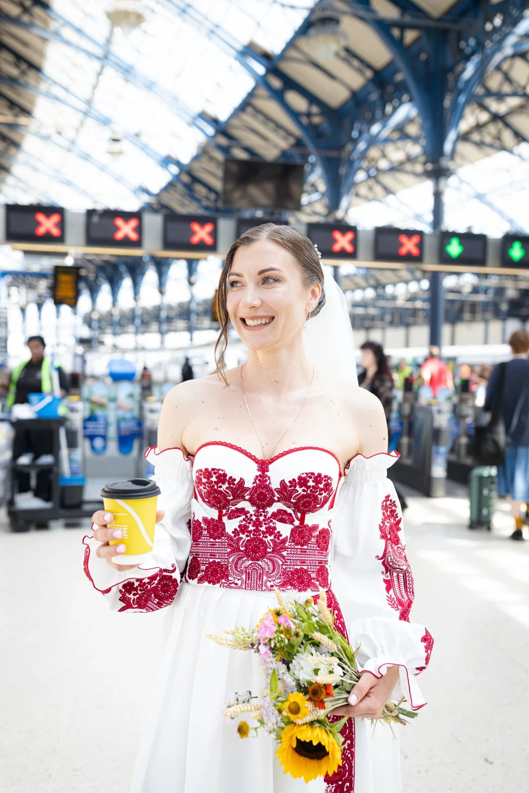 Lena with her coffee and wedding bouquet at Brighton station.