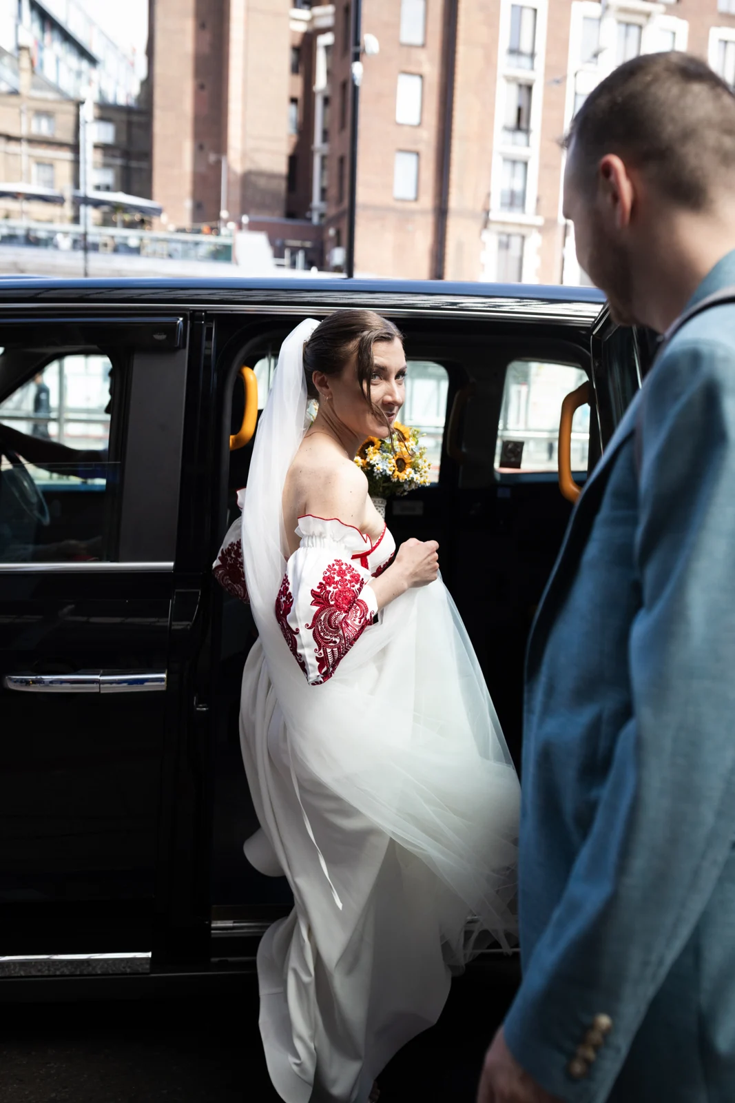 Lena stepping into a black cab with Arturs beside her in London.