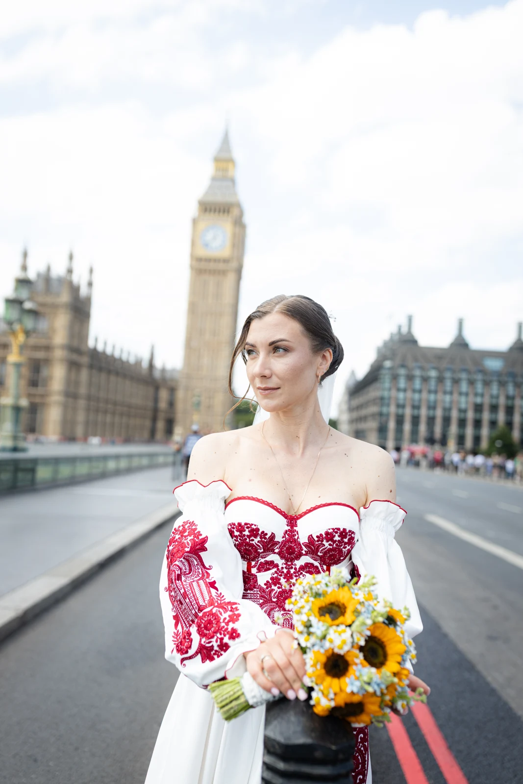 Lena holding her sunflower bouquet on Westminster Bridge.