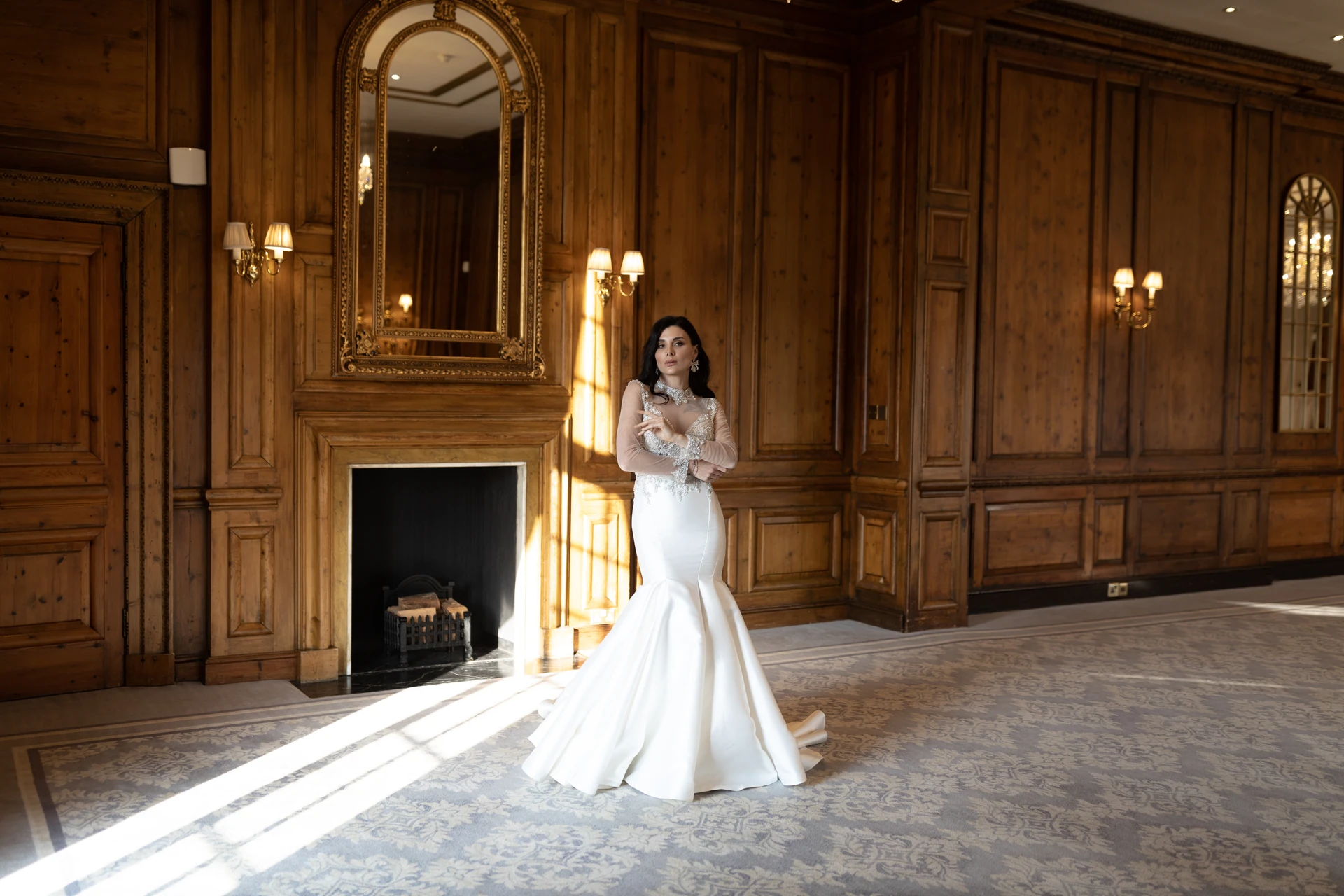 Angelina standing in a pool of sunlight in a wood-panelled room at Hedsor House