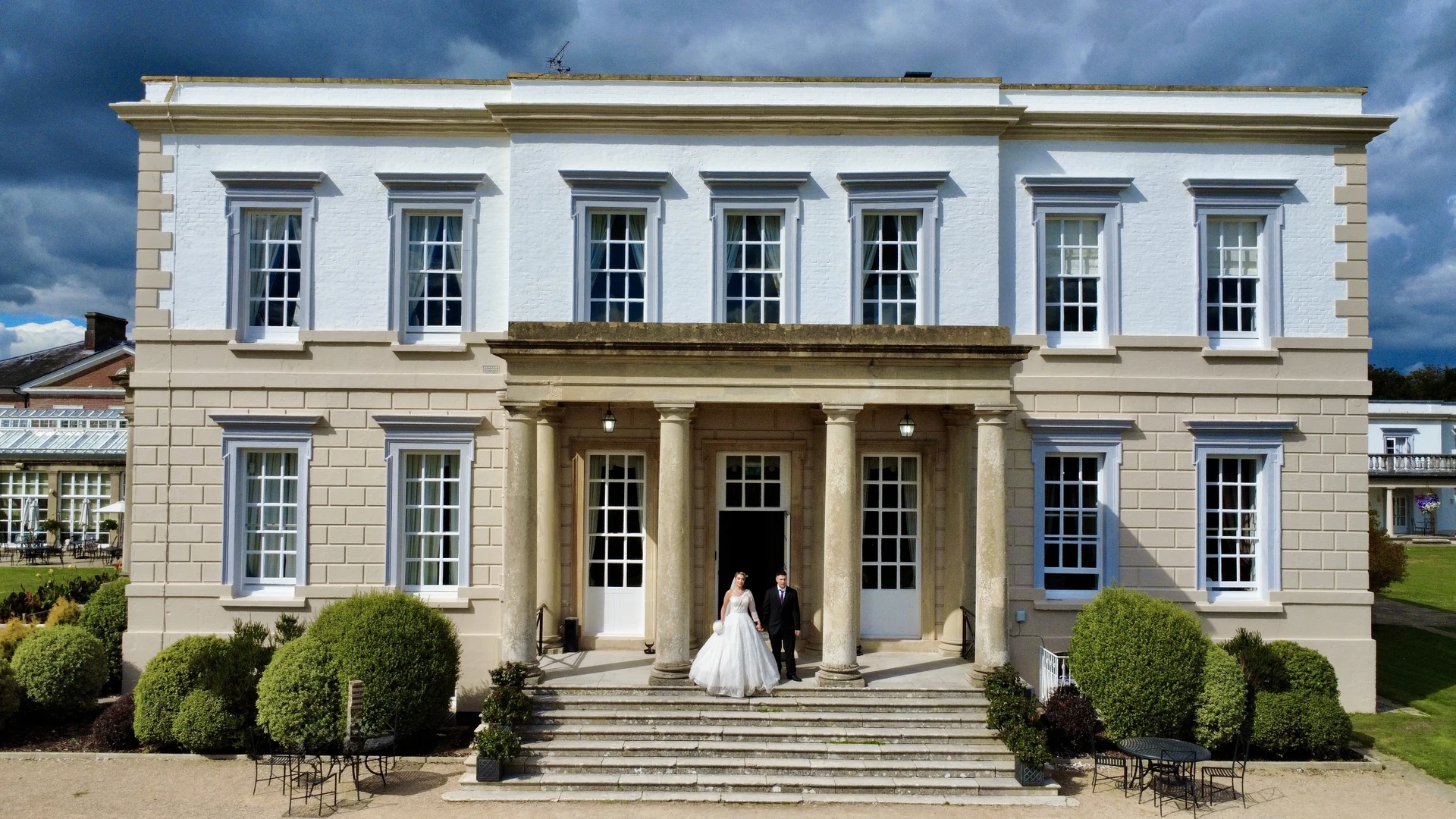 A couple framed by the columns at Buxted Park Hotel
