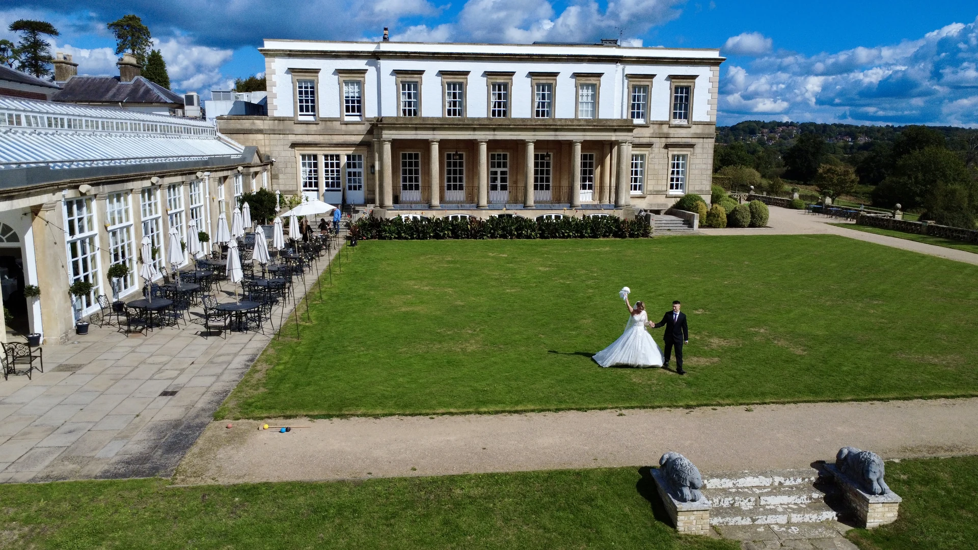 A couple celebrating on the lawn at Buxted Park Hotel