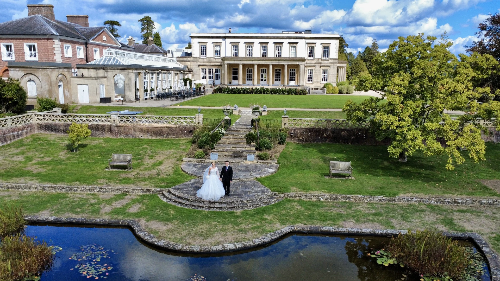 Drone wedding portrait beside the pond at Buxted Park Hotel in East Sussex
