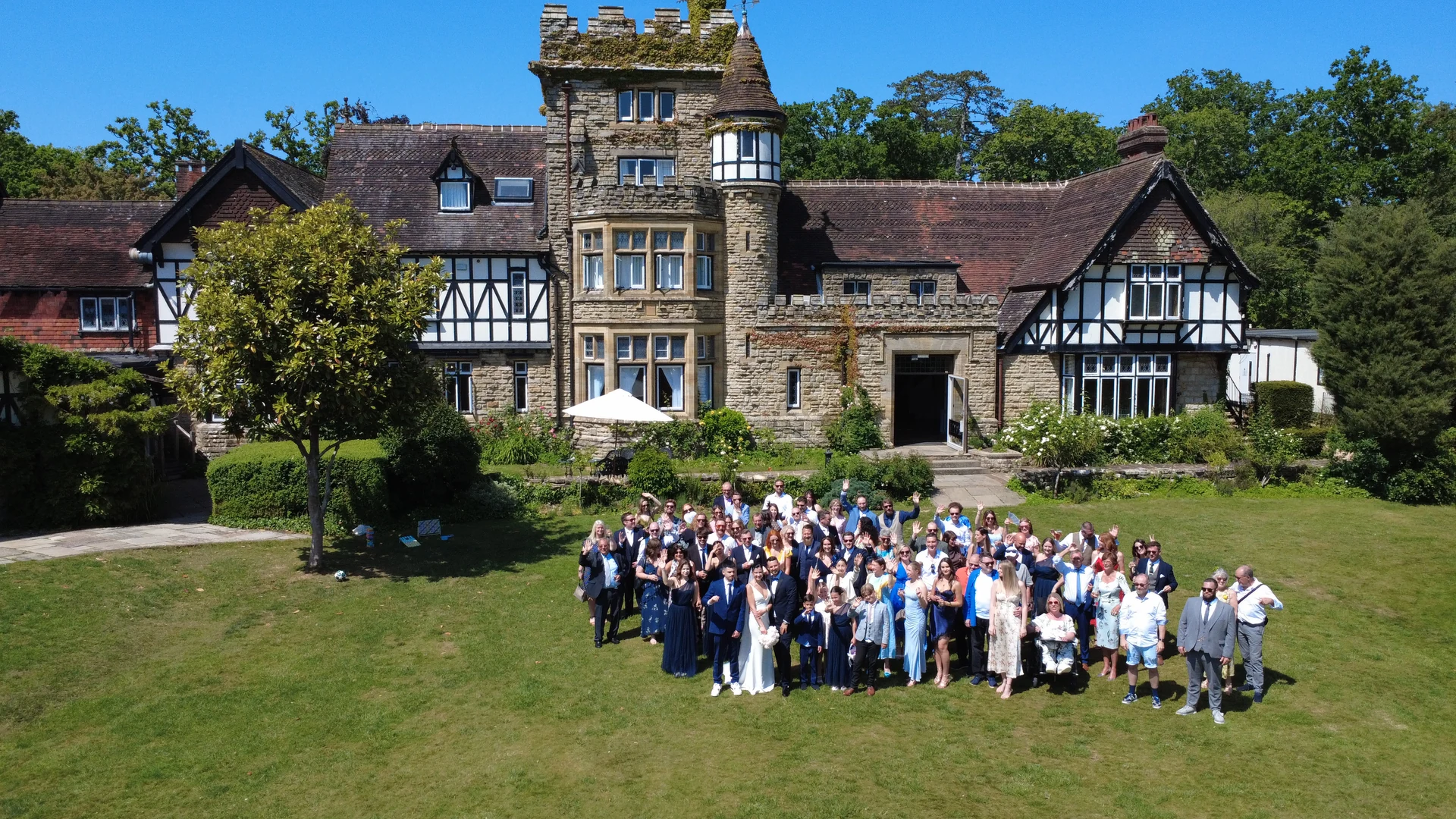 Jen and Stu with their wedding guests: a drone photograph at The Ravenswood in Sussex