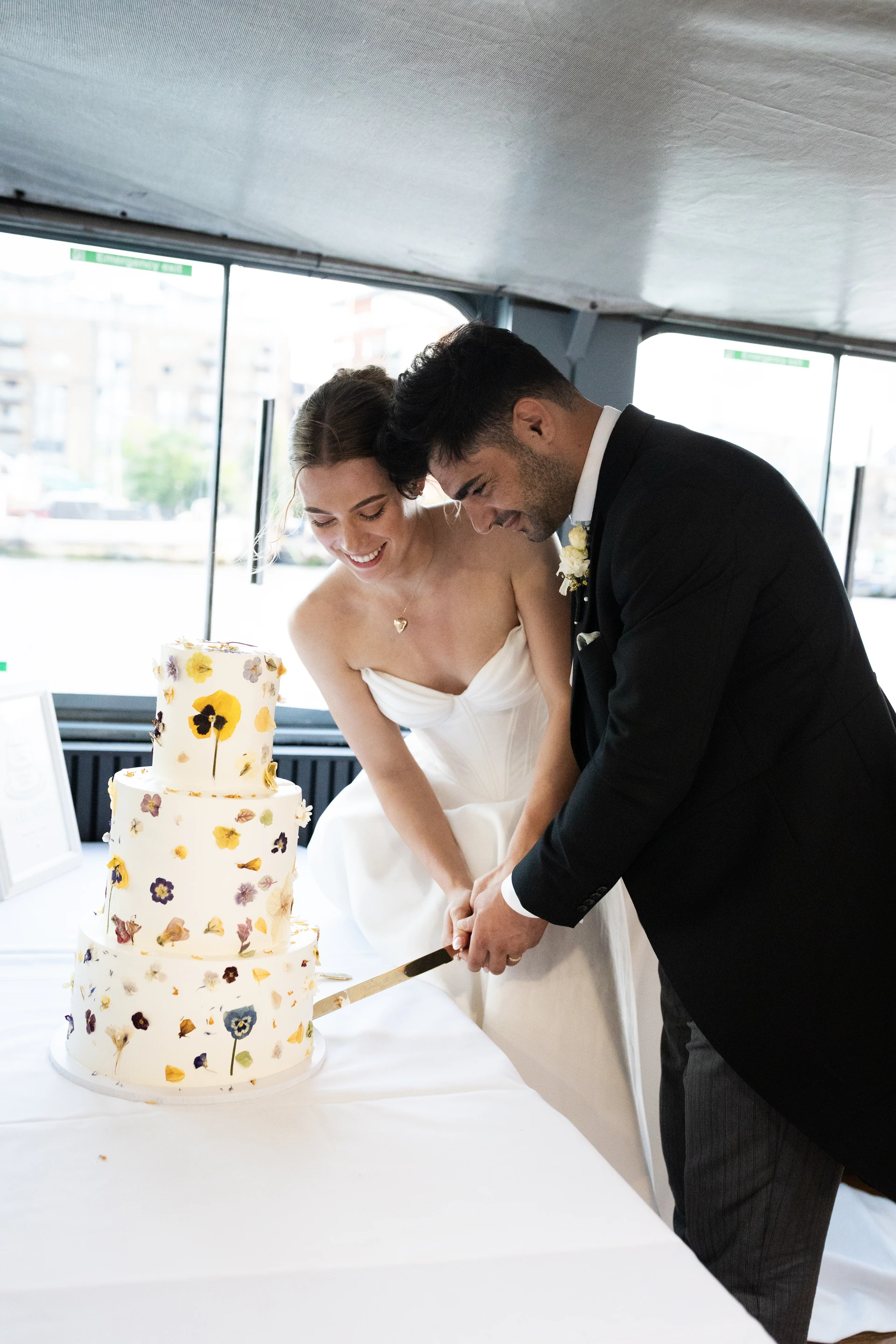 Celebrating together beside their wedding cake