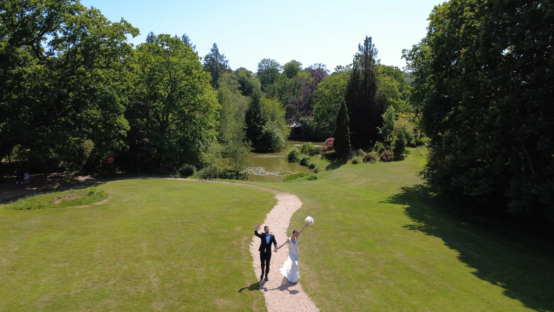 Jen and Stu holding hands in an aerial wedding photograph at The Ravenswood in Sussex